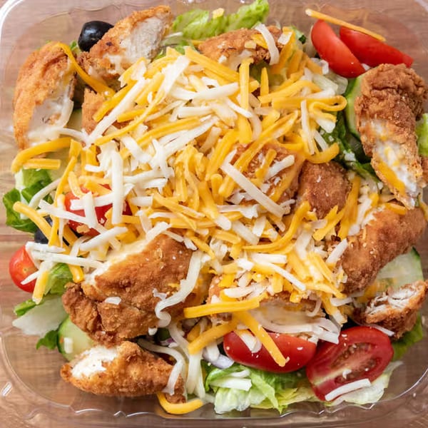Giovanni's Pizza fried chicken salad with lettuce, tomatoes, olives, and shredded cheese.